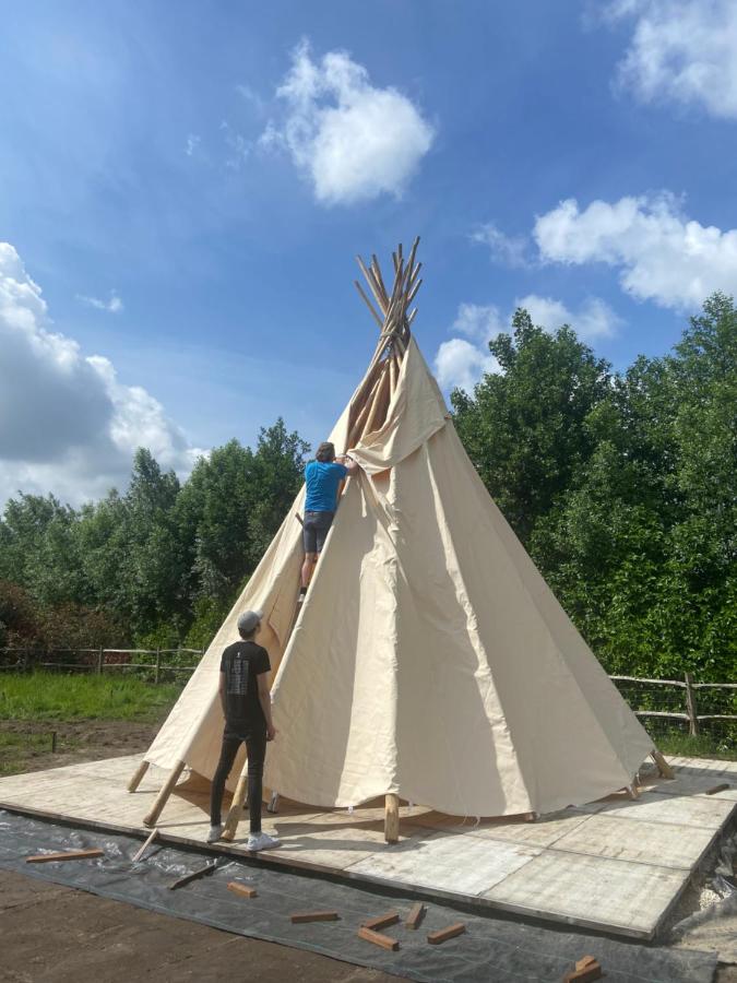 Tipi tent opbouw in België: tipi op een vlonder in de tuin aan bosrand - Yurtkopen